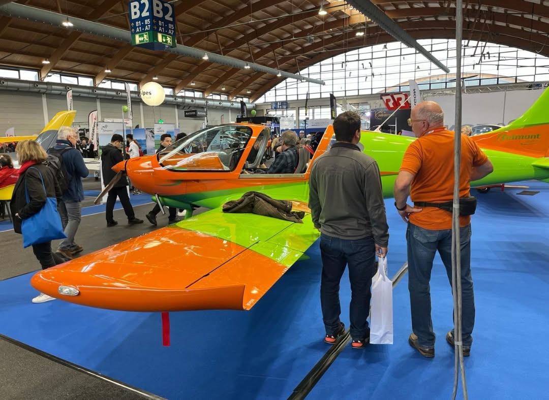 Visitors viewing an orange and green Belmont aircraft at AERO Friedrichshafen