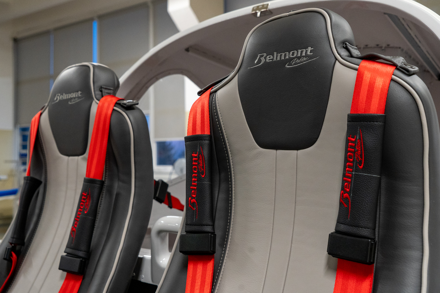 Hand-fitted leather seats with red harnesses in a Belmont aircraft